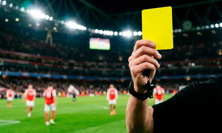 Apuestas a tarjetas en la Premier League con árbitro mostrando tarjeta